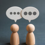 two wooden figures simulating conversation